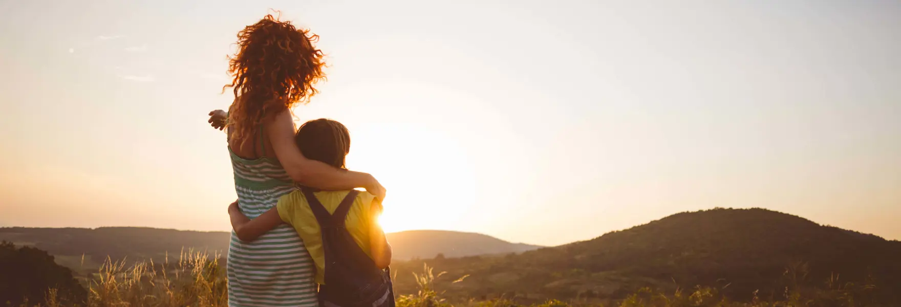 Ragazza e bambino che osservano il paesaggio al tramonto 